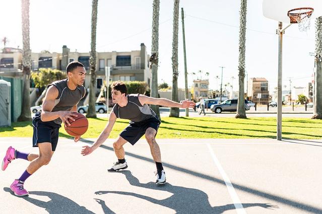 Two guys playing basketball at the park